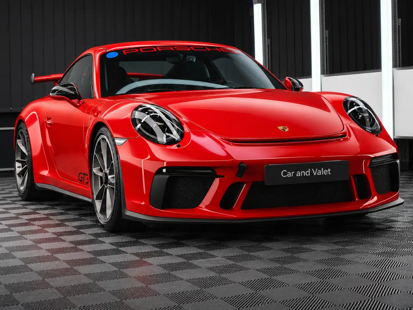 Roter Porsche 911 GT3 auf dem Werkstattboden im Lichttunnel von Car and Valet