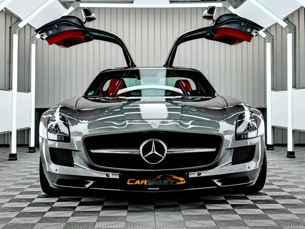 Silberner Mercedes-Benz SLS AMG mit geöffneten Flügeltüren im Lichttunnel.