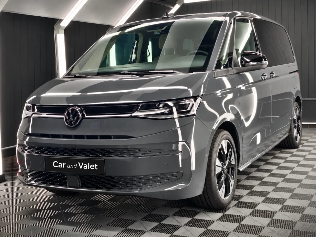 Grauer VW T7 Multivan im Lichttunnel von Car and Valet, schräg von vorn fotografiert.