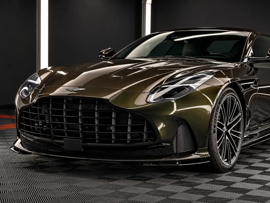 Dunkler Aston Martin DB12 im Lichttunnel von Car and Valet, Ansicht von schräg vorn