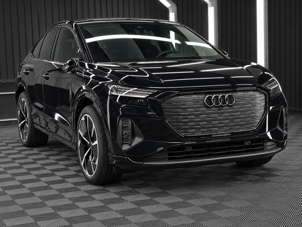 Schwarzer Audi Q4 e-tron im Ausgangszustand vor der grünen Color-PPF-Folierung.