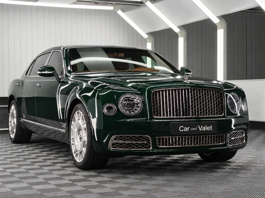 Dunkelgrüner Bentley im Lichttunnel von Car and Valet, schräg von vorn fotografiert.