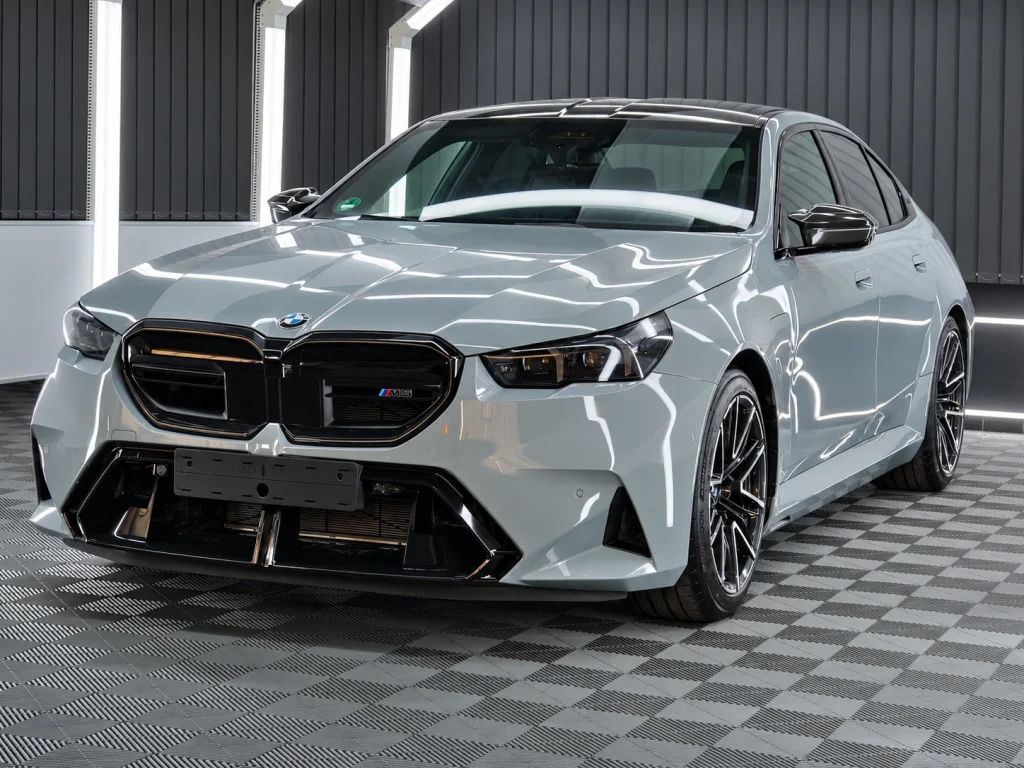 Hellgrauer BMW M5 mit dunklen Felgen im Lichttunnel von Car and Valet.