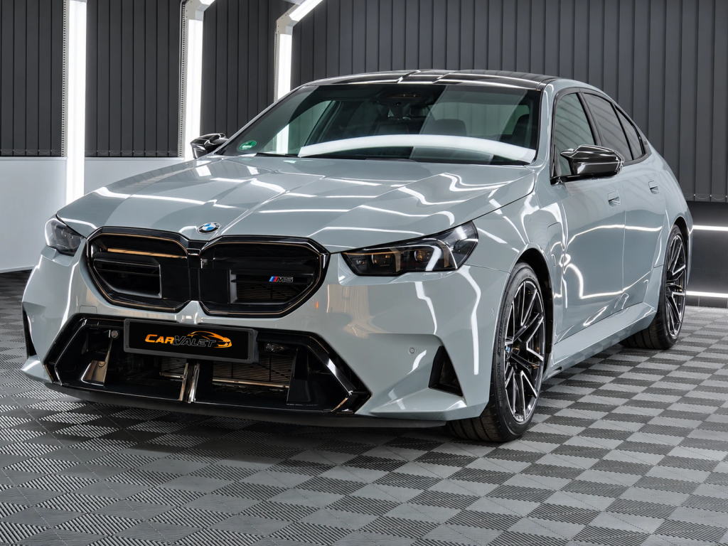 Hellgrauer BMW M5 mit dunklen Felgen im Lichttunnel von Car and Valet.