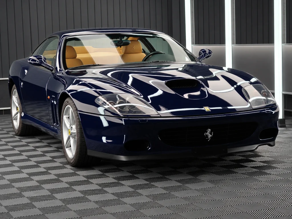 Dunkelblauer Ferrari 575M Maranello mit silbernen Felgen, schräg von vorn im Lichttunnel von Car and Valet.