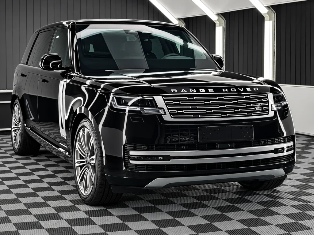 Schwarzer Range Rover mit silbernen Mehrspeichenfelgen, schräg von vorn im Lichttunnel von Car and Valet.