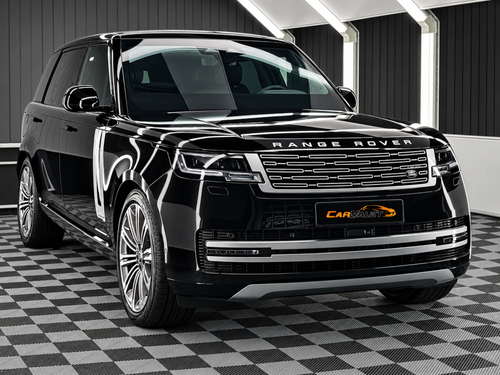 Schwarzer Range Rover mit silbernen Mehrspeichenfelgen, schräg von vorn im Lichttunnel von Car and Valet.